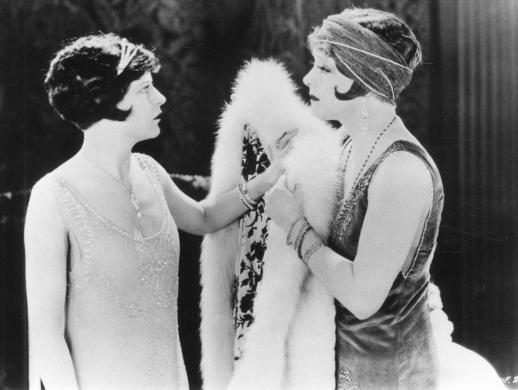 Zwei Frauen im Stil der 1920er schauen sich an