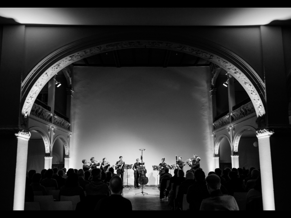 A group of musicians plays in a large vault